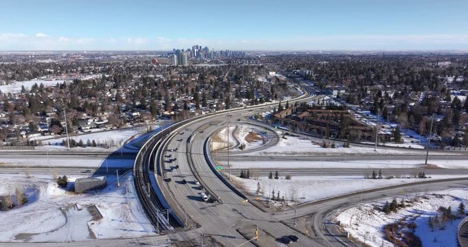 Aerial flyover of 17th Avenue SW and Sarcee Trail with light traffic toward downtown Calgary in winter, Alberta, Canada.