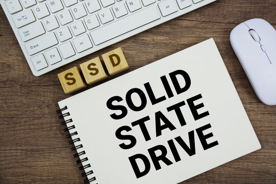 SSD Solid State Drive message with keyboard and optical mouse on wooden background