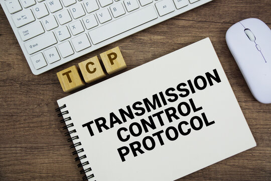 TCP Transmission Control Protocol message with keyboard and optical mouse on wooden background