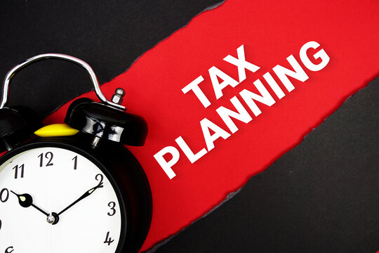 Tax Planning with alarm clock on red background