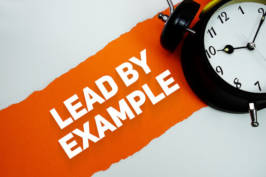 Lead By Example with alarm clock on orang background