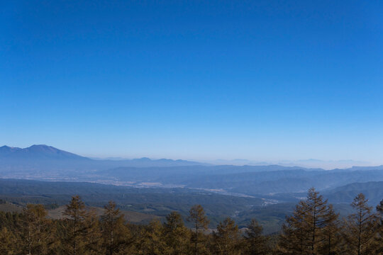 八千穂高原から見下ろす広大な佐久平と霧が湧く連なる山並み／長野県・10月