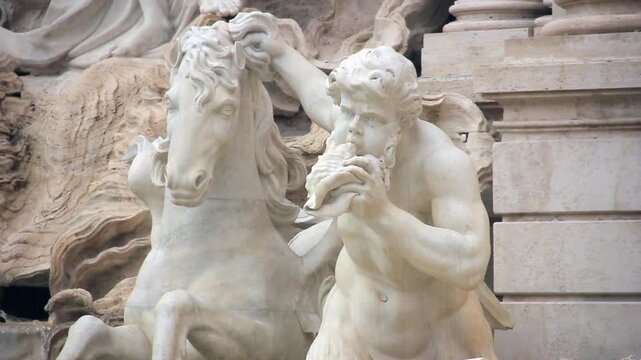 Close Up View Of Triton Sculpture Blowing Conch Shell At Trevi Fountain In Rome Italy