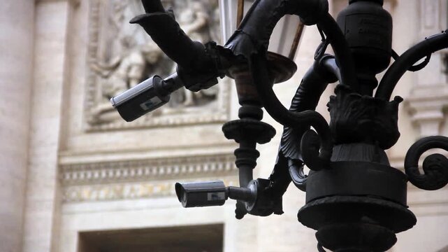 Security Cameras Mounted On Street Lamp In Front Of Trevi Fountain Facade In Rome Italy