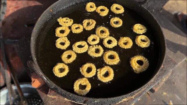 Fresh delicious indian imarti sweet ring dessert frying in hot oil 4k video footage