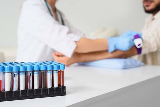 Blood test and medical diagnostics, phlebotomist drawing blood from patient arm for laboratory analysis and health screening in a clinical setting