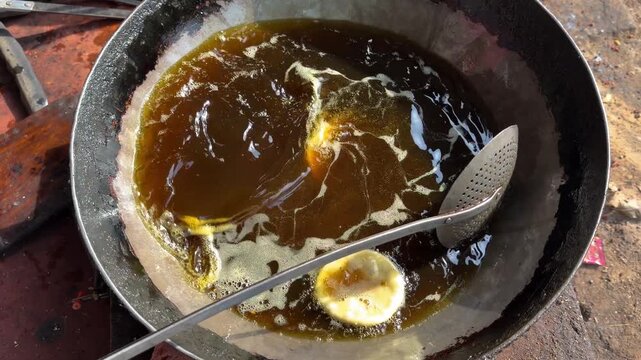 Deep frying indian puri bedai or kachori bread in hot oil 4k video footage