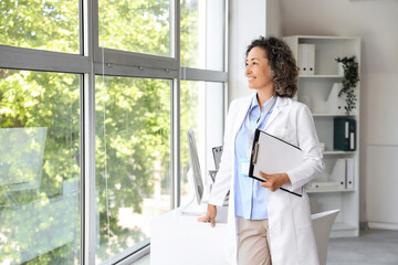 Healthcare professional and medical career, female doctor standing in office with clipboard looking...