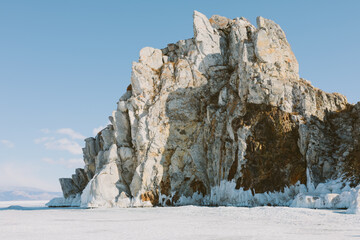 Rugged marble Shamanka Rock rises above frozen Lake Baikal near Khuzhir in Irkutsk Oblast, Russia, showing dramatic icicles, textured stone, and tranquil Siberian winter wilderness scenery © TravelFlow