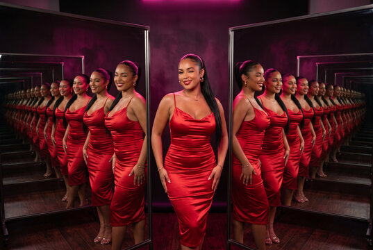 Glamour mirror portrait of a woman in red satin dress
