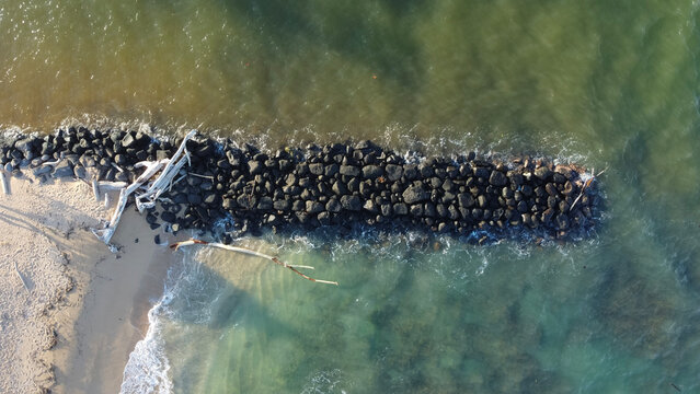 Driftwood Along Rock Breakwater at Fuji Beach Kauai Hawaii Aerial View