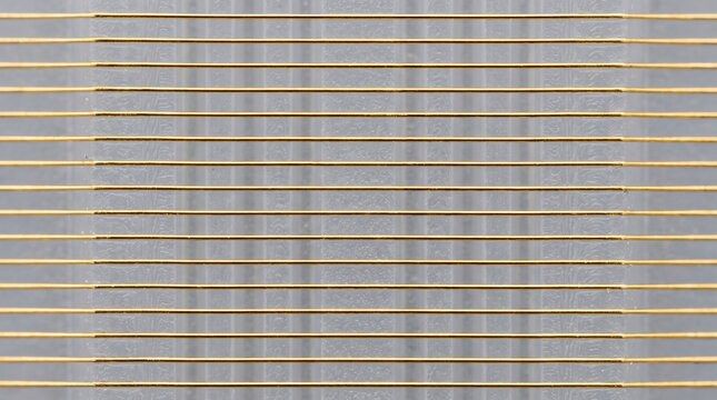 Gold thread silicone creates precise linear texture with metallic contrast, minimalist craft detail and tactile material