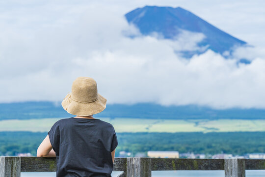 後ろ姿の女性と富士山｜山中湖・湖畔から夏の富士山を眺める女性・日本の風景