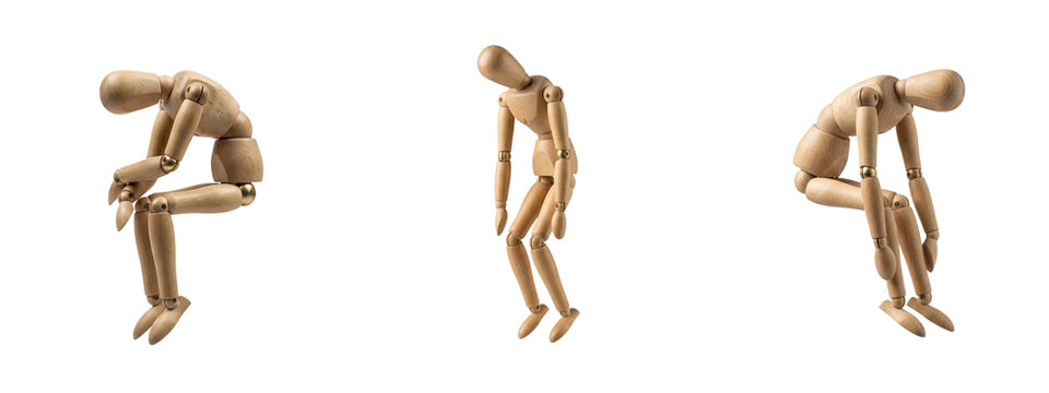 Wooden manikins posing with sad slumped postures on transparent background