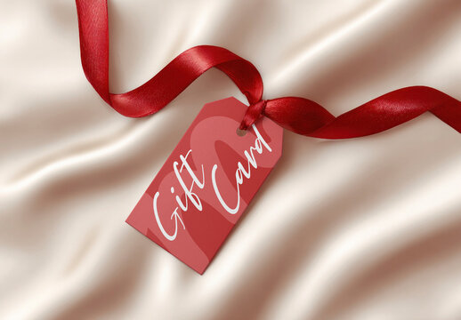 Gift Card Mockup PSD With Red Ribbon On Silky Beige Fabric Background