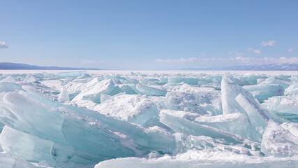 Crystalline hummocks of clear turquoise ice cover the frozen surface of Lake Baikal in Irkutsk Oblast, Russia, showing massive blocks under a clear blue sky on a cold day © TravelFlow