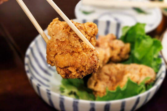 ストライプ柄の深い丼鉢に盛られた鶏の唐揚げ