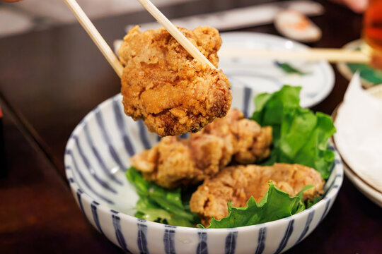 ストライプ柄の深い丼鉢に盛られた鶏の唐揚げ