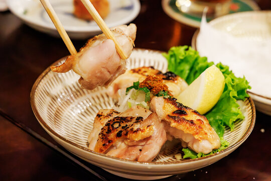 レモンと薬味が添えられた地鶏の炭火焼き