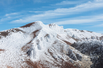 Frozen crust and fresh white snow cover the volcanic slopes and rugged crater rim of Avachinsky Volcano in Kamchatka Krai, Russia, beneath a bright sunny sky © TravelFlow