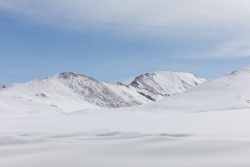 Panoramic view of snow covered mountain peaks and frozen highland valley across Arabel Plateau in Issyk-Kul Region Kyrgyzstan creating a serene scenic winter wilderness landscape © TravelFlow