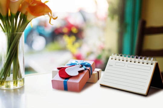 close-up shot, diary book for new year's greeting messages and gift box on desk with flower in vase, christmas item, New Year's 2027 festival concept