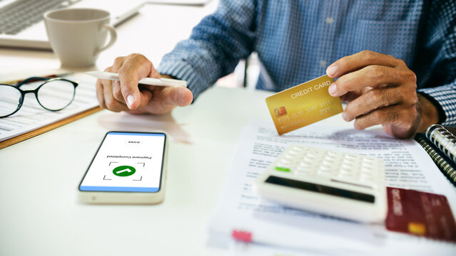 close-up shot, asian man holding credit card to shopping online and success payment via mobile app, home shopping concept