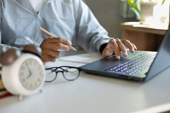 asian man in casual clothes working online at home, taking note and using laptop to due business, E commerce business concept