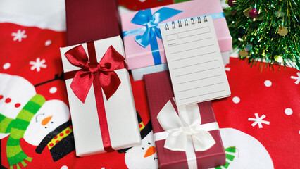 close-up shot, gift box with christmas items on table and diary for new year's greetings message, New Year's 2027 festival concept © Lek