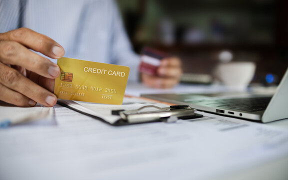 close-up shot, man hand holding credit card calculate expenses from receipt and bills before paying credit card debt