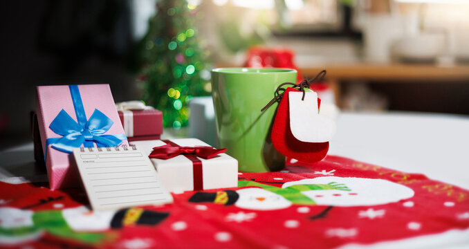 close-up shot, green coffee cup with christmas item on table and gift box, diary for new year's greetings message, New Year's 2027 festival concept