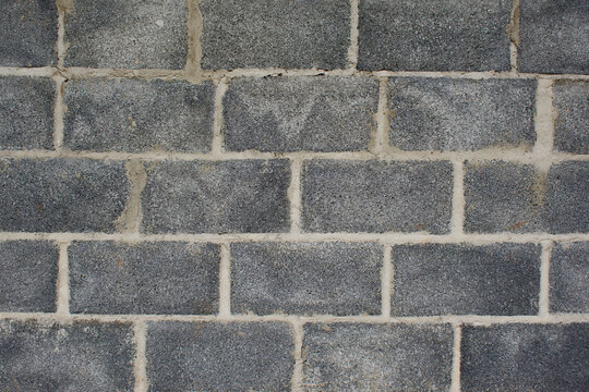 Gray concrete block wall with rough texture and light mortar joints.