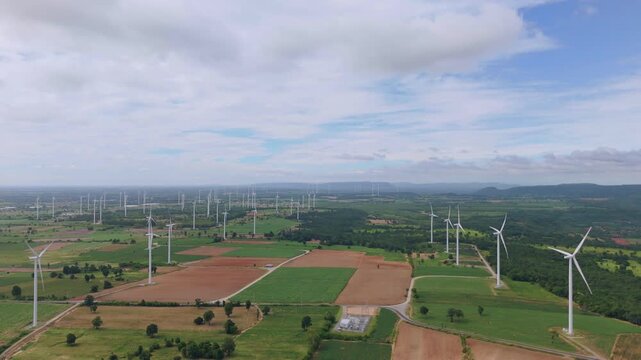High angle aerial view of wind farm and electrical substation over farmland for renewable power