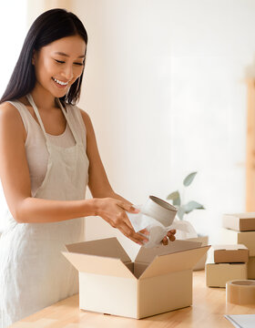 Woman packing an ecommerce order at home for her small business