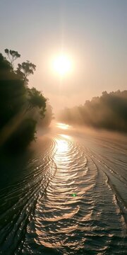 Riverbanks wrapped in morning mist, sun's rays dance on rippling water, nature, ||Golden light