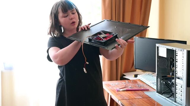 Teenage girl assembling side panel with fan on computer case slow motion