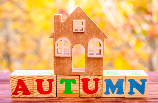 House symbol on a background of yellow autumn leaves

