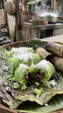 Traditional Indonesian steamed rice cake with palm sugar and grated coconut served on a banana leaf.