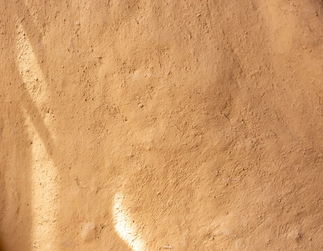 Soil wall texture of clay house structure with sunlight. Mud background