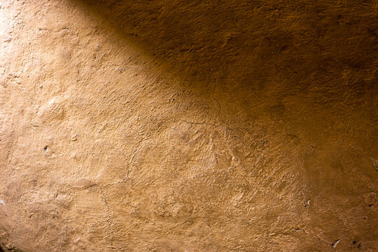 Soil wall texture of clay house structure with sunlight. Mud background