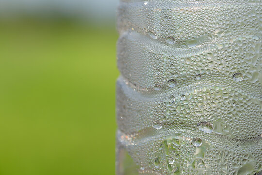 water drops on bottle and green blurred background 