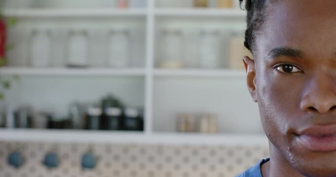 Adult man shifting to smile reacting to cue, camera shot showing kitchen jars, copy space