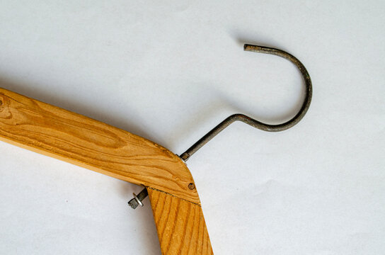 Wooden coat hanger with a metal hook on a white surface