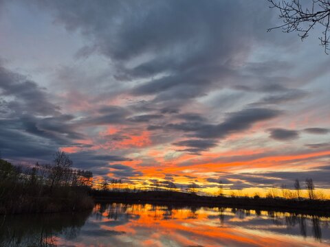 iTramonto sul fiume con cielo nuvoloso e riflessi dorati