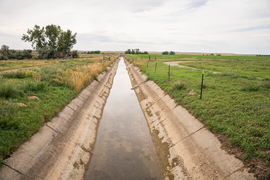 Long irrigation canal runs through rural grasslands