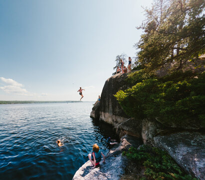 Friends enjoying a sunny day of cliff jumping at the lake