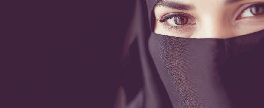 Woman's expressive eyes looking, wearing black niqab veil, representing modesty and culture