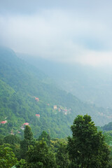 Scenic hill station landscape in India with green mountains, misty valleys and forest. Beautiful Himalayan scenery, ideal for travel, tourism, nature and holiday destination themes. © Sanket Mishra
