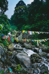 Waterfall cascading over rocks in lush green forest at a hill station in India. Scenic Himalayan nature landscape, ideal for travel, tourism and outdoor themes. © Sanket Mishra