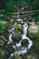 Waterfall cascading over rocks in lush green forest at a hill station in India. Scenic Himalayan nature landscape, ideal for travel, tourism and outdoor themes. © Sanket Mishra